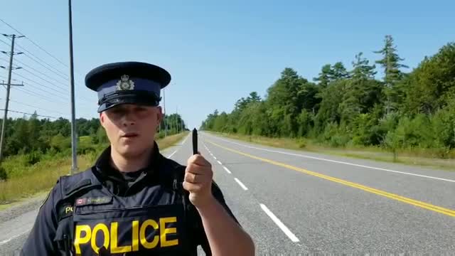 Un policier cache quelque chose derrière son stylo