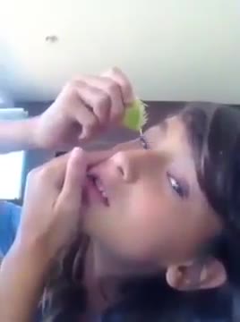 Une fille presse un citron sur son oeil