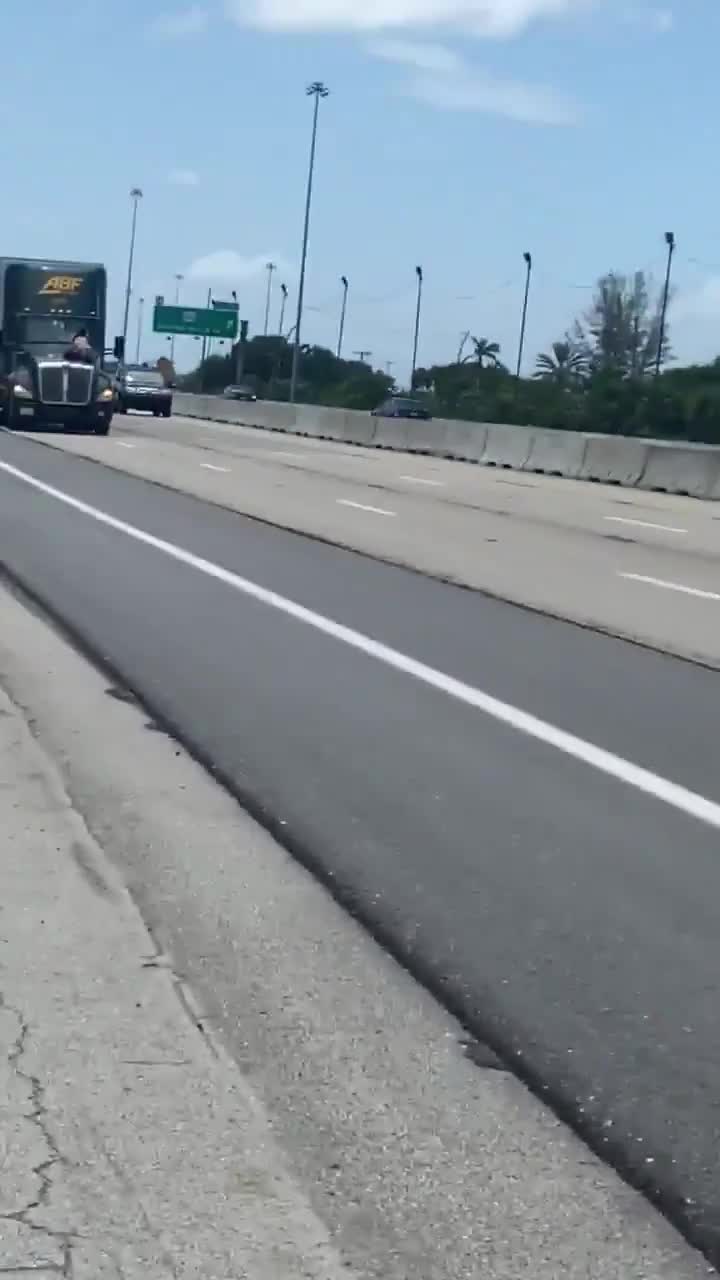 Un homme s'accroche sur le capot d’un camion en pleine l’autoroute