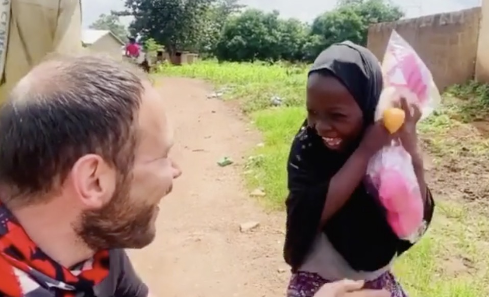Un bénévole offre une poupée à une petite fille nigérienne