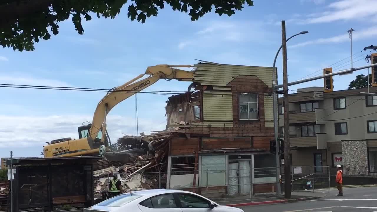 Un piéton passe à coté d’une démolition de maison
