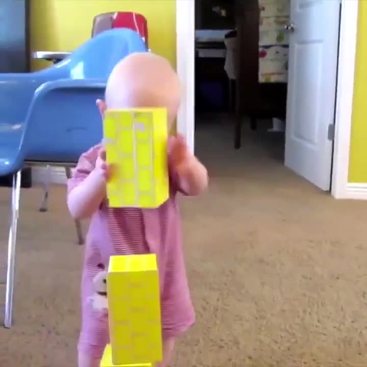 Un bébé super content d'empiler ses cubes